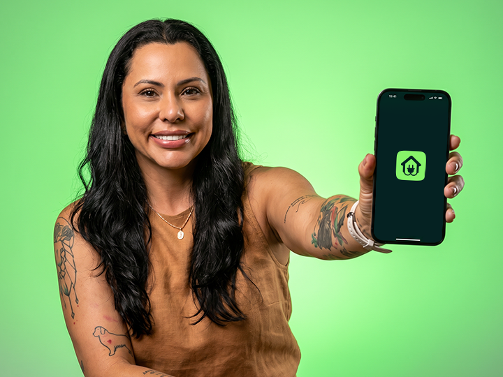 Polly Araújo, fundadora do Éter, em fundo Energy Green segurando o app